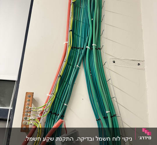 חוטי חשמל ירוקים ואדומים מותקנים על קיר